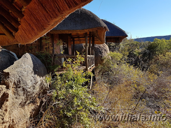Thatched wooden cabin among rocks at Mhlangeni Bush Camp