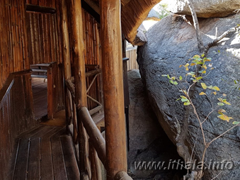 Narrow wooden walkway built around a large boulder at Mhlangeni Bush Camp