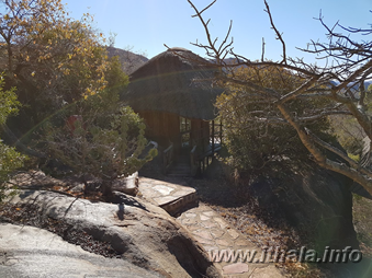 Stone walkway beside a thatched cabin at Mhlangeni Bush Camp