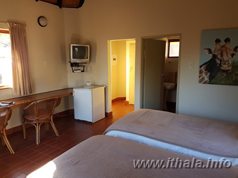Twin beds and refreshment area in a two-sleeper non-self-catering chalet at Ntshondwe Camp