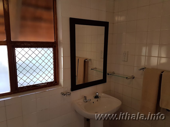 Bathroom washbasin and mirror inside a two-sleeper chalet at Ntshondwe Camp