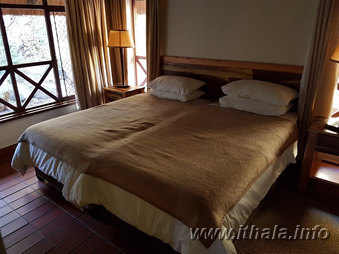Twin bedroom with two single beds inside a six-bed chalet at Ntshondwe Camp